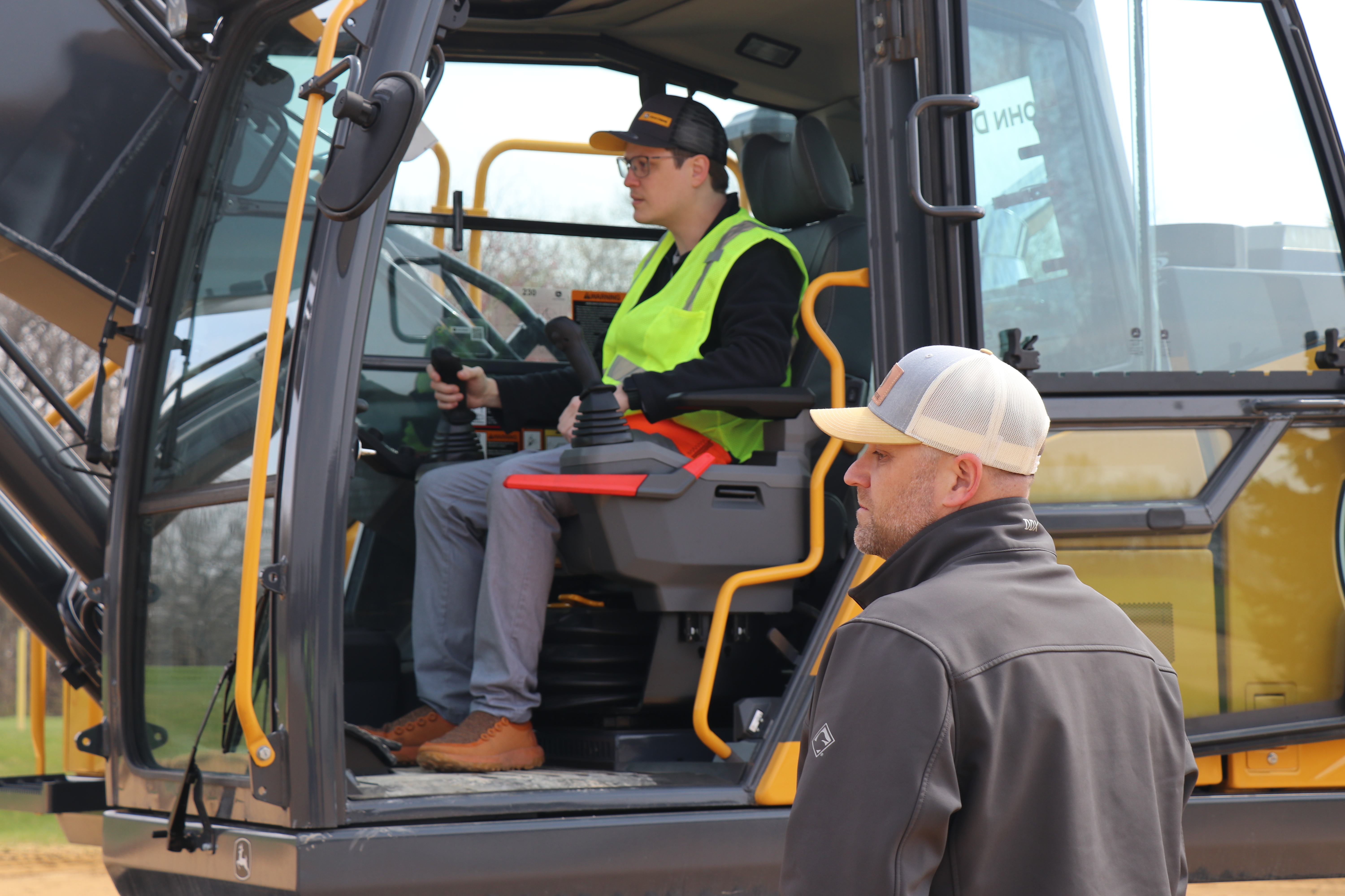 Excavator operator and observer at open cab