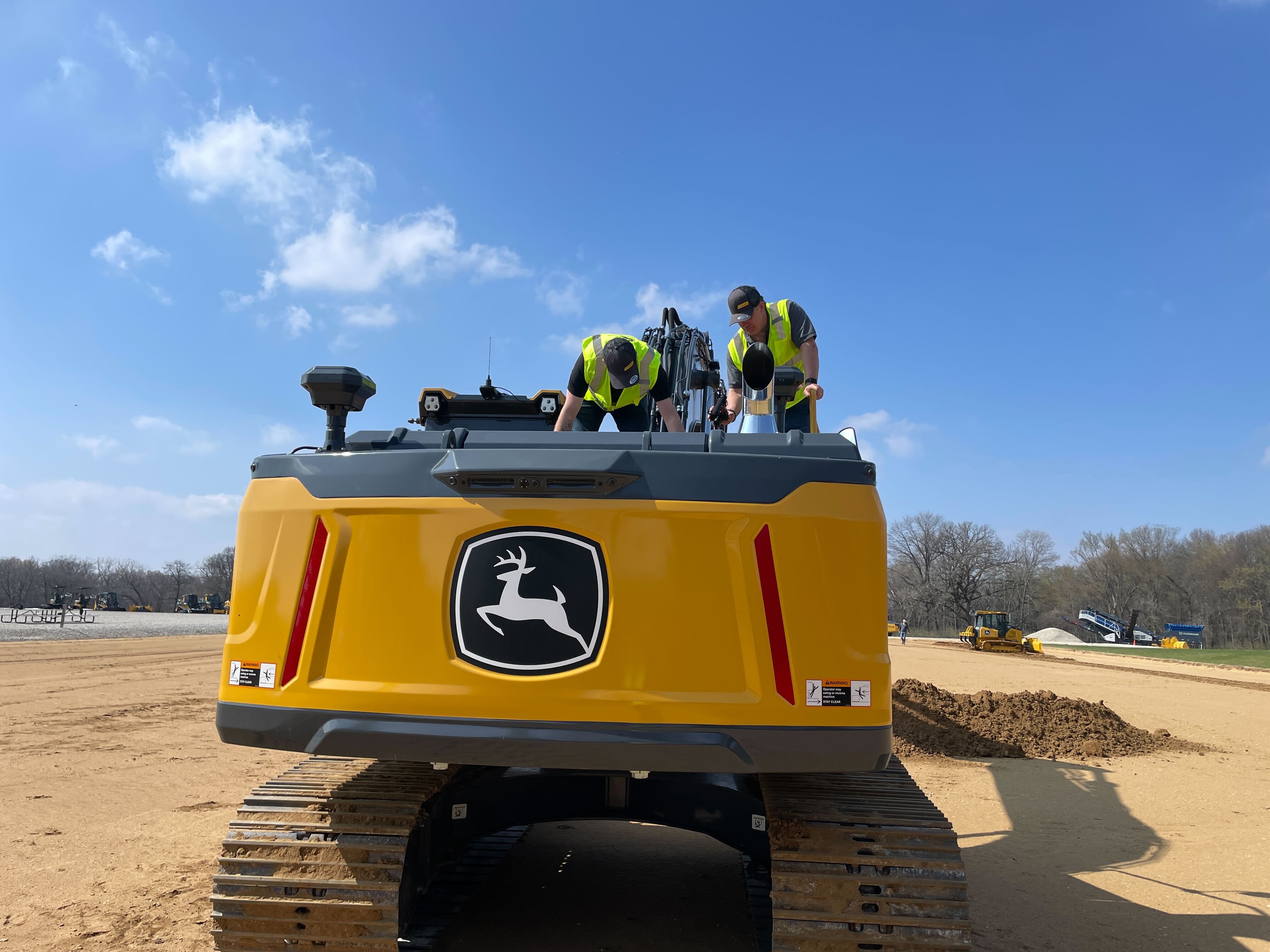 Team inspecting excavator upper deck