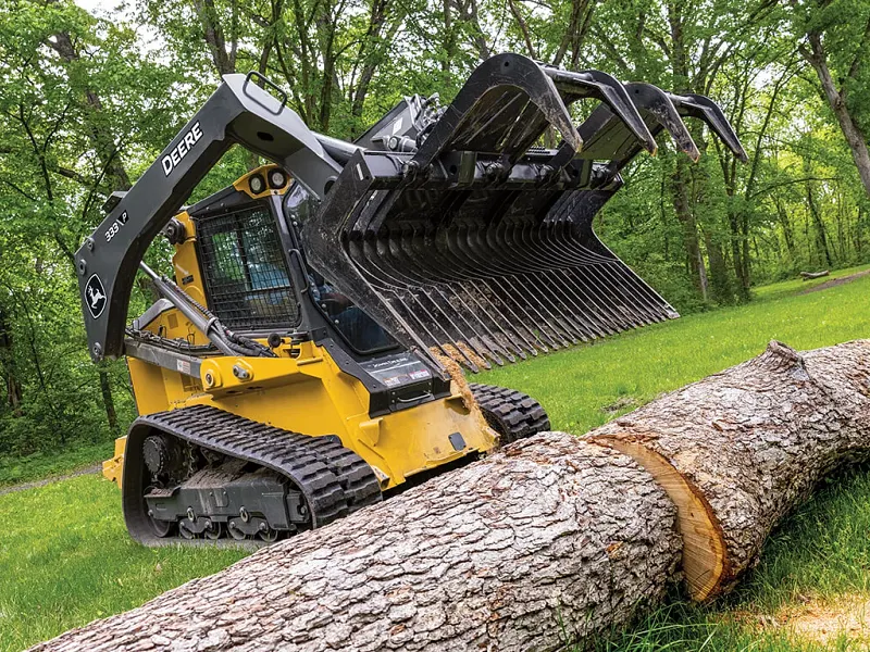 John Deere 333 P-Tier gallery — 333 P-Tier compact track loader using John Deere grapple attachment to move large log.